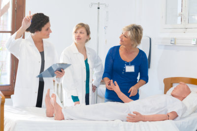 nurse raising hand to ask question during training with mannequin answer